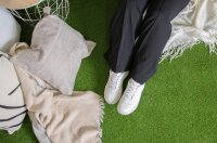 Bildbeschreibung: Das Bild zeigt in vier Bereichen die Einsatzmöglichkeiten von Kunstrasen im Außenbereich. Oben links ist ein Balkon mit Stühlen auf Kunstrasen, daneben eine Terrasse mit Sofa und Pflanzen. Unten links ist ein Hochbeet oder eine Zierfläche mit Kunstrasen und weißen Steinen, unten rechts ist ein aufblasbarer Pool auf Kunstrasen. Darüber steht der Text „Geeignet für viele Außenbereiche“.