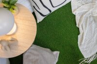 Rolle mit grünem Kunstrasen, teilweise ausgerollt. Auf dem Etikett steht „Erhältlich in 2 Breiten“. Im Vordergrund ist ein Kreis mit einer Nahaufnahme des Kunstrasens und einem Symbol für die Florhöhe von 22 Millimetern.