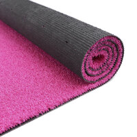 Nahaufnahme einer pinkfarbenen Fußmatte mit strukturierter, rauer Oberfläche, nur eine Ecke der Matte ist sichtbar, Hintergrund weiß.