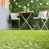 Montage aus vier Bildern: Oben links Balkon mit zwei Klappstühlen und Kunstrasen, oben rechts Gartensofa mit Tisch auf Kunstrasen, unten links Zierfläche mit Kunstrasen und weißem Kies, unten rechts aufblasbarer Pool auf Kunstrasen. Text: Geeignet für viele Außenbereiche: Balkon und Terrasse, Garten, Zierflächen, Pool-Unterlage, uvm.